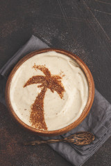 Vegan banana coconut smoothie bowl with a palm tree carob decoration. Vegan healthy food concept, top view.