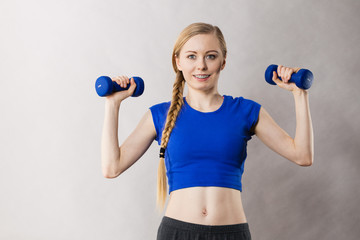 Teenage woman working out at home with dumbbell