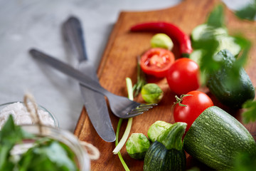 Fresh vegetable salad and ripe veggies on cutting board over white background, close up, selective focus