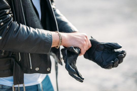 biker putting on leather gloves to drive his motorbike