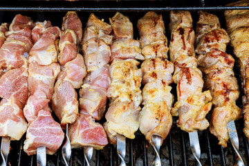 Marinated shashlik preparing on a barbecue grill over charcoal. Shashlik or Shish kebab