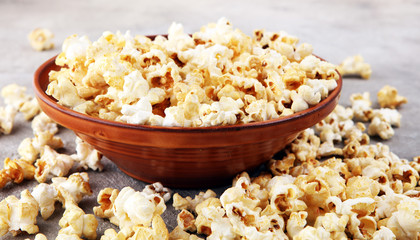 Salt popcorn or sweet popcorn on old grey background.