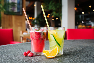Orange lemonade with cucumber and lemonade with  berries  on the stone desk