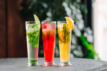Cold fruit tea with apples, oranges and berries on the stone desk background