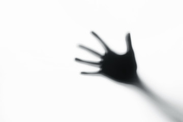 Hands silhouette behind a glass