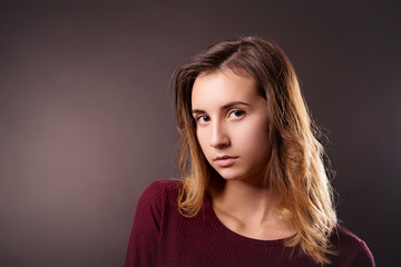 Girl with hair ombre and clean skin on a dark background close-up