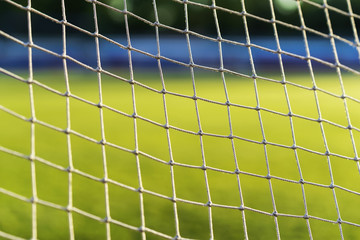 Soccer goal net pattern on green live, on background of green football field close-up