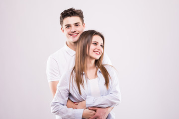 Concept of romantic relationship between man and woman. Girl with bronze skin woman and handsome man are standing isolated on grey background