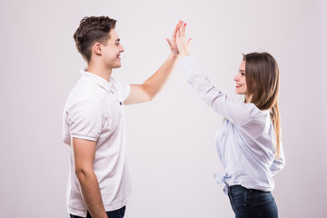 Joyful man and woman greeting each other with a high five isolated on white