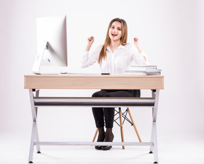 Excited businesswoman at desk with pc computer isolated on white background