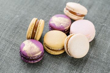 Fototapeta na wymiar Close-up colorful French or Italian macaron on white wooden table. Macarons is French dessert served with tea or coffee. wallpaper, Horizontal photo