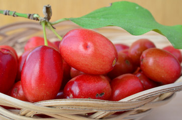 Organic red Cornelian cherries in a basket, close up