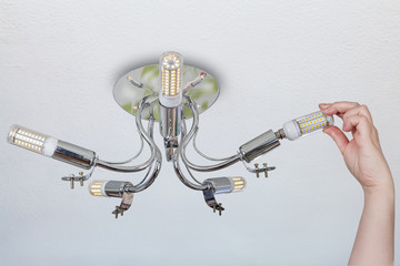 Naklejka premium Installation of LED lamps such as corn in ceiling chandelier.