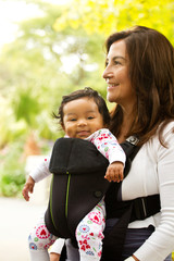 Mom holding her baby in a carrier.