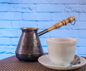 White mug and coffee maker on the table