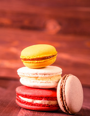 Stack of colorful macaroons on a wooden background