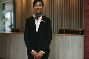Female concierge ready to welcome guest - obrazy, fototapety, plakaty