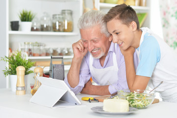 Obraz na płótnie Canvas Senior man with grandson preparing dinner