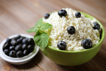 Cottage cheese and blueberry in a bowl on a table. Good breakfast