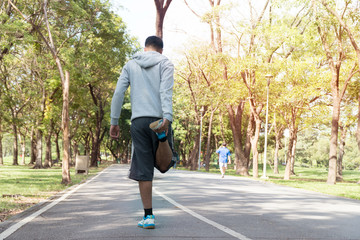 The back of yong man sportswear doing stretching exercise relaxing and warm up after jogging and running in park with copy space. sport, lifestyle concept