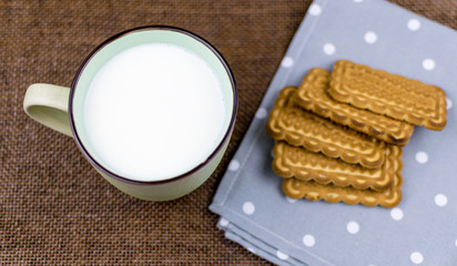A cup of milk and cookies.