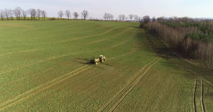 Tractor spray fertilize on field with chemicals in agriculture field.