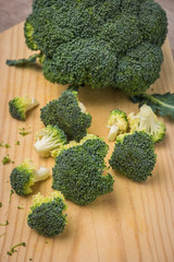 Raw uncooked broccoli chopped on wooden board. Healthy cooking concept