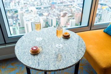 Gourmet pastries with white wine in a room high above the city