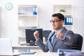 Young handsome businessman employee working in office at desk