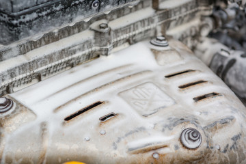 Wash the engine with foam. The engine is in the foam for washing the car. Hoses in the foam.