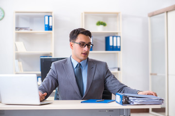 Young handsome businessman employee working in office at desk