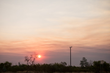 Naklejka na ściany i meble Smokey sunset near Tenant Creek in the outback of the Northern Territory in Australia