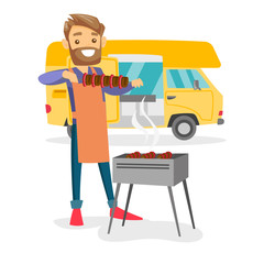 Young caucasian white man preparing meat on grill on the background of camper van