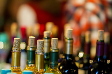 Many open wine bottles with corks on an abstract blured background, still life