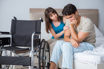 Desperate man on wheelchair with his sad wife