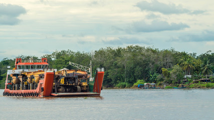 Obraz premium ship loaded with heavy machinery for mining purpose cruising Mahakam river, Borneo, Indonesia