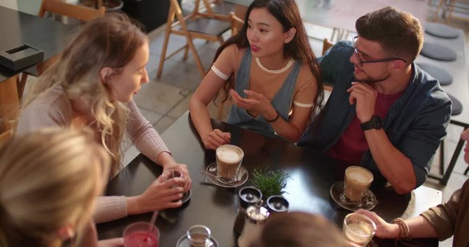 Young multi-ethnic friends having fun together at urban cofffee shop
