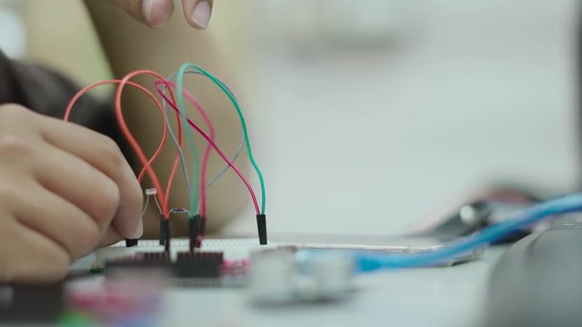 Students in Asian workshop uniform using iot development kit for educational science experiment