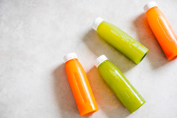 Plastic bottles of cold-pressed unprocessed fruit and vegetable juices, from above, light gray table. Body cleance, fast concept. Minimalism food photography