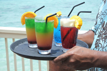 Pacific islander male waiter serving cocktails on a tropical pacific island resort in Rarotonga Cook Islands