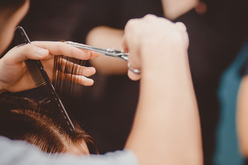 Barbershop. Close-up of man haircut, master does the hair styling in barber shop