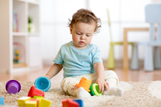 baby kid toddler playing toys at home or nursery