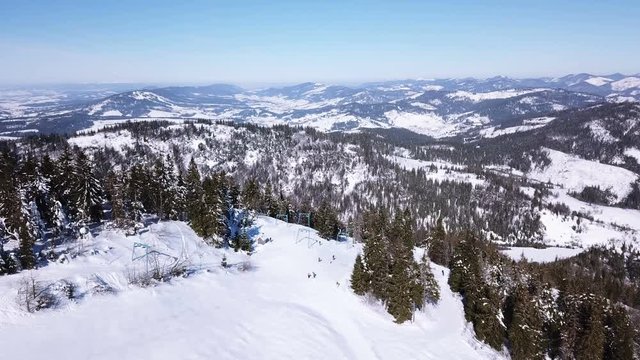4k.Aerial. Skiers silhouettes and mountains hills in sunny day