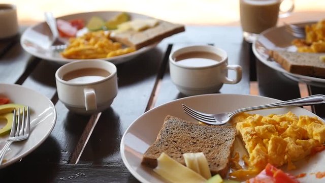 Delicious breakfast on white plates with smoked sandwiches and fruit. slow motion. 1920x1080. full hd