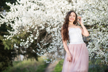 Young woman in the garden blooming in spring