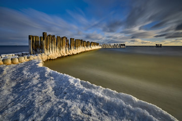 Frozen wooden breakwaters line to the world war II torpedo platform at Baltic Sea, Babie Doly,...