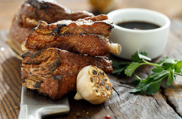 Beef ribs cooked on a grill on a wooden board with copy space