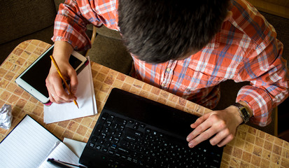 laptop tablet and notebook with pencil on the table with a man