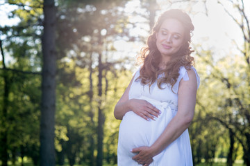 Pregnant woman in a spring park