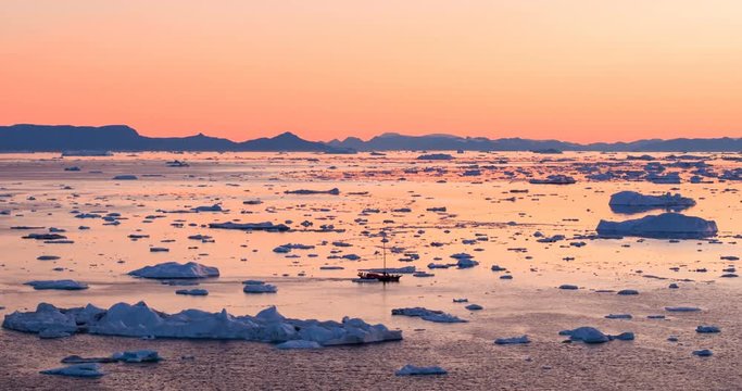 Ice and Icebergs from glacier - amazing arctic nature landscape aerial video of icefjord filled with icebergs from melting glacier Sermeq Kujalleq, Ilulissat, Greenland. Midnight sun.